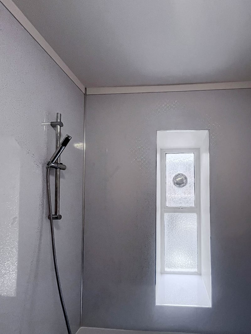 The same bathroom, the wall above the bath, after the works