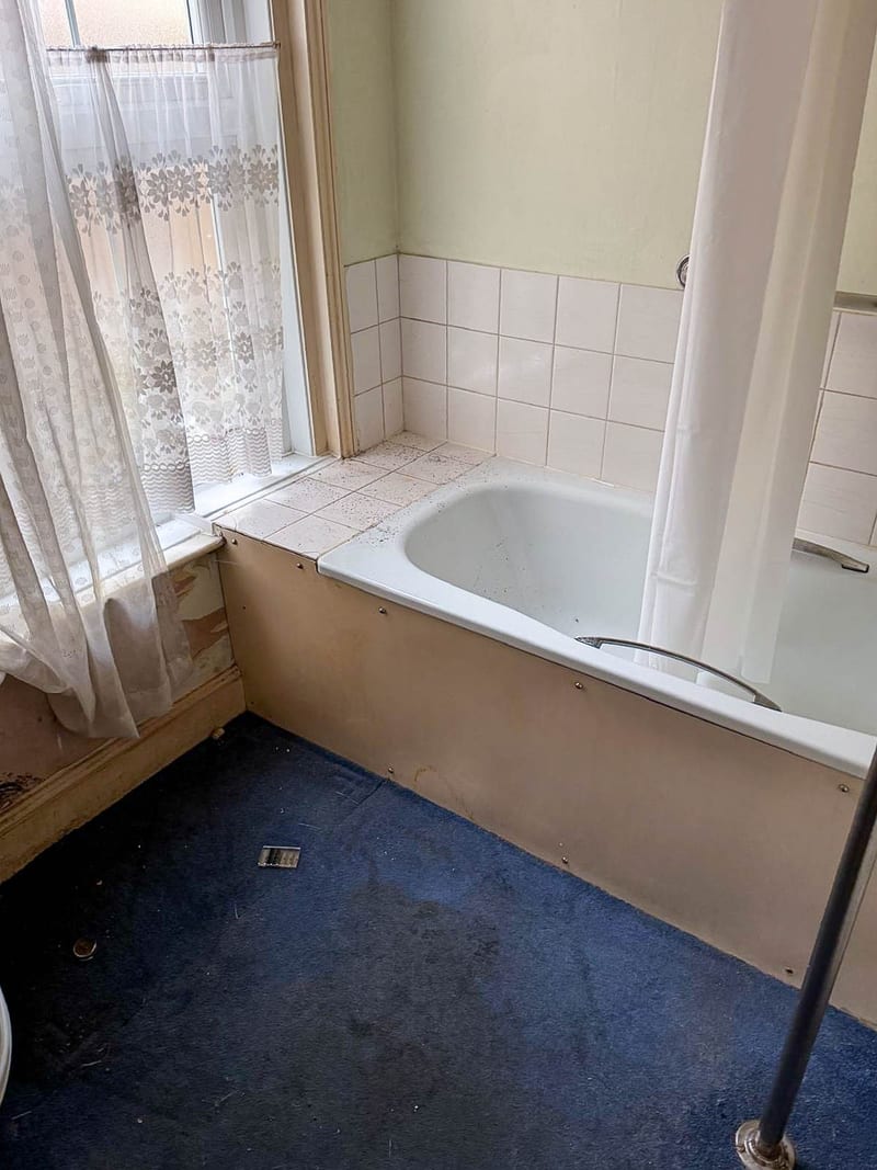 A second property, the bath below the window, before the works