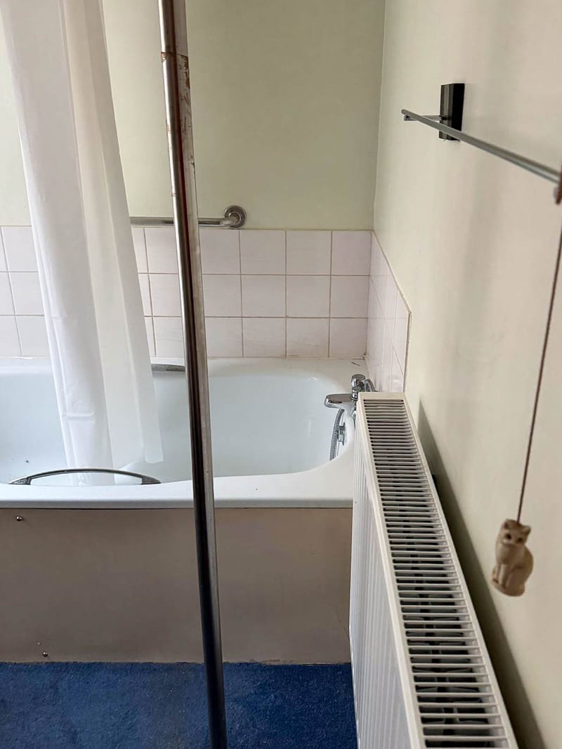 The same bathroom, along the shower and radiator wall, before the works