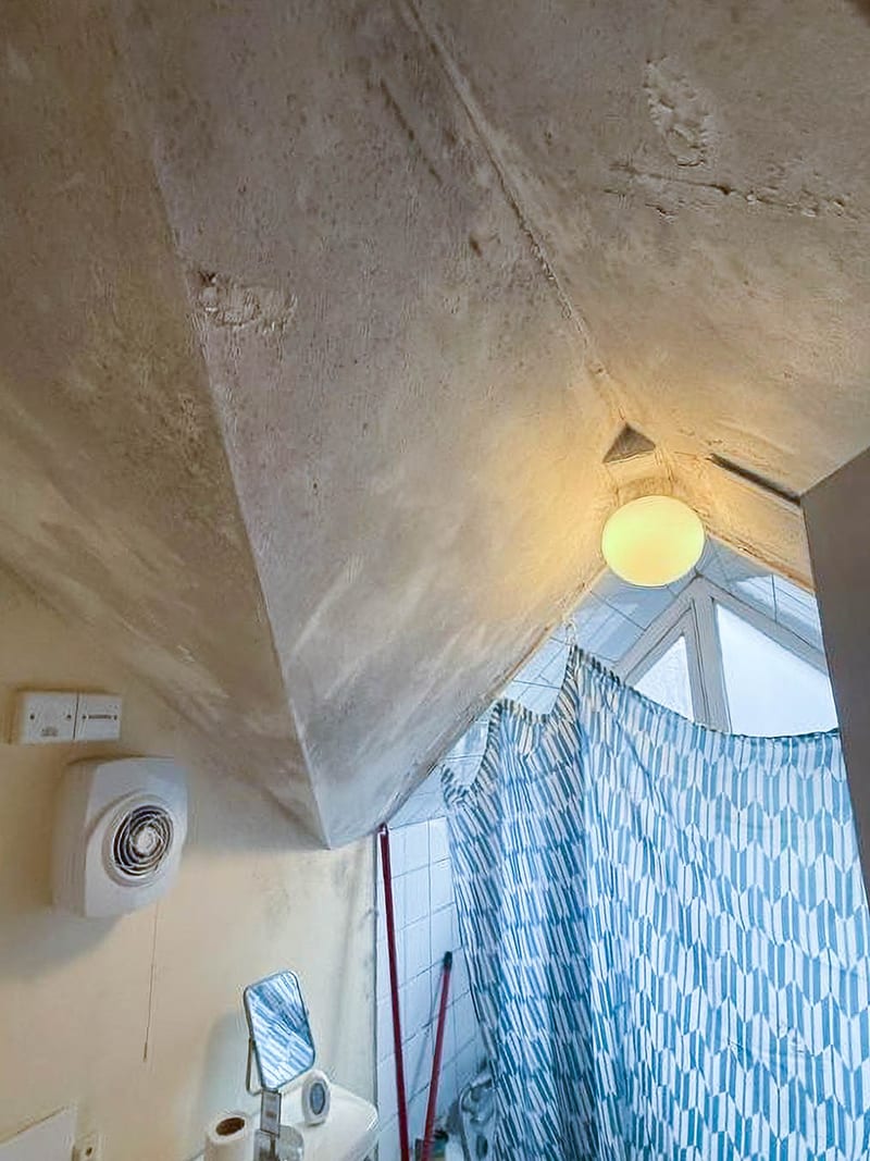 A bathroom ceiling in the same property, before the works